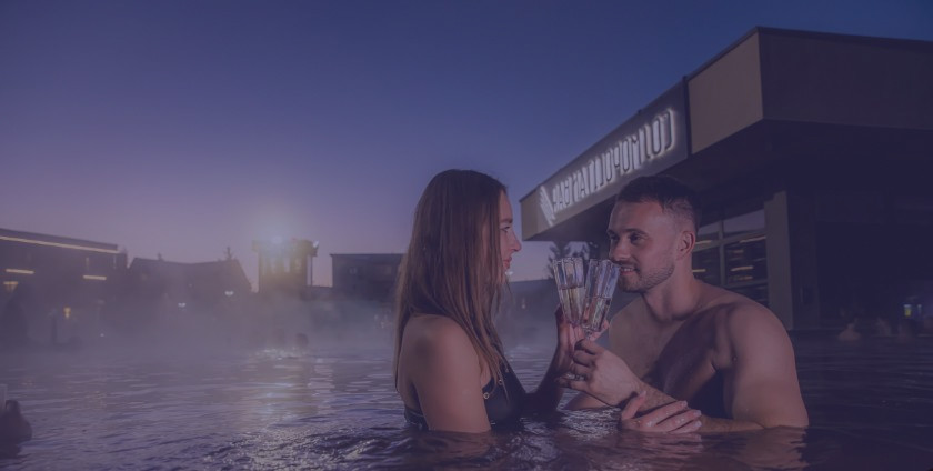 Evening bathing in thermal pools with a drink and starlit relaxation.